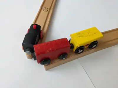 A toy train with wooden tracks at a 60° angle